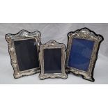 A modern silver photograph frame with a triple arched top decorated with scrolls and leaves,