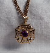 A yellow metal pendant in the shape of a pierced Maltese Cross,