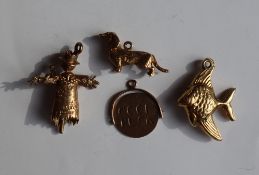 Four 9ct gold charms including a fish, scarecrow, dog and rotating Good Luck, approximately 7.