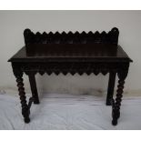 A 19th century carved oak side table, the raised back carved with arched and flowers heads,