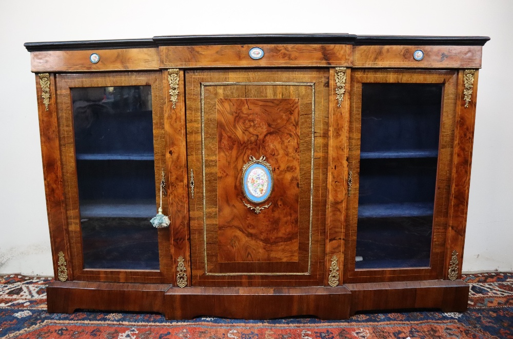A Victorian walnut credenza the breakfront top with ebonised edge above a central cupboard and two