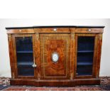 A Victorian walnut credenza the breakfront top with ebonised edge above a central cupboard and two