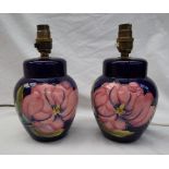 A pair of Moorcroft pottery table lamps, decorated with pink magnolias to a blue ground,