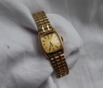 A Lady's 9ct yellow gold Omega De Ville wristwatch, the gilt rectangular dial with batons,