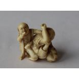 A 19th century Japanese ivory figure group of two men fighting and a boy,