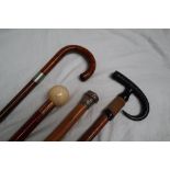 A white metal topped bamboo walking stick together with an antler handled walking stick,