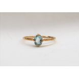 An aquamarine ring, the oval faceted aquamarine to a yellow metal setting and shank, size Q,