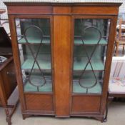 An Edwardian mahogany display cabinet with a pair of glazed doors with glazing bars and glazed