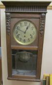 An early 20th century oak wall clock,