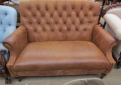 A Brown leather two seater settee with button back upholstery