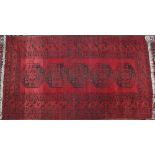 A red ground Turkoman rug with five geometric medallions to a red ground together with a rug with