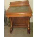 A Victorian walnut Davenport with a raised stationery compartment, sloping fall,