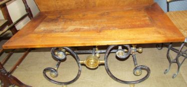 A 20th century coffee table with a scrolling cast iron and brass base