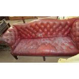 A red leatherette three piece suite with button back upholstery on square legs
