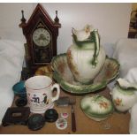 A 19th century steeple clock together with a pottery wash basin set, pottery lions,