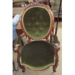 A Victorian walnut framed child's elbow chair with a varied back and scrolling legs