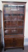 A Regency style mahogany bookcase with a moulded cornice and single glazed door with glazing bars,