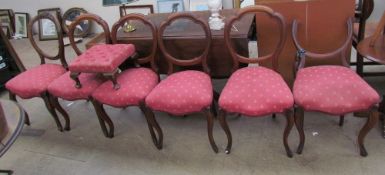 A matched set of six Victorian balloon back dining chairs together with a foot stool