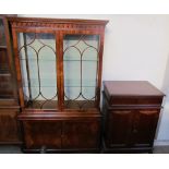 A 20th century mahogany bookcase with a moulded cornice above a pair of glazed doors,