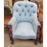 A Victorian button back upholstered library chair with carved from on scrolling legs and casters
