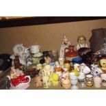 A collection of pottery egg cups together with novelty tea pots, commemorative mugs, jugs,