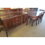 A 20th century mahogany extending dining table with four chairs and a matching sideboard,