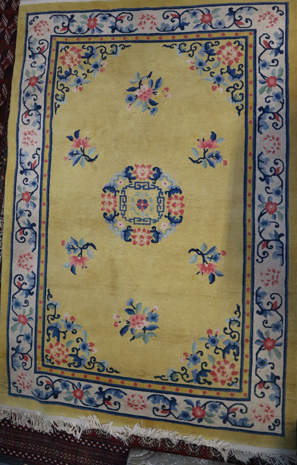 A Chinese rug, yellow field with central medallion in ivory foliate main border,