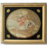 A George III silkwork picture of oval form depicting a figure in a turban and a reclining maiden
