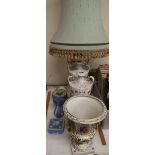A continental porcelain urn with winged lion handles together with a pair of floral decorated vases,
