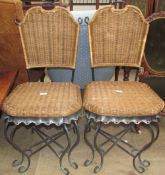 A pair of scrolling metal and wicker work dining chairs