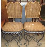 A pair of scrolling metal and wicker work dining chairs