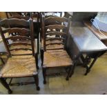 An oak gate leg dining table and four ladder back chairs