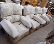 A set of four conservatory armchairs with floral upholstery and another wicker armchair