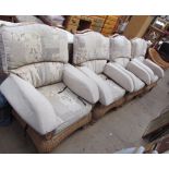 A set of four conservatory armchairs with floral upholstery and another wicker armchair