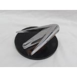 A chrome car mascot / hood ornament, possibly from a Buick,