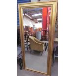 A tall gilt wall mirror
