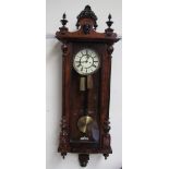 A walnut cased Vienna regulator type wall clock with a cream enamel dial and Roman numerals and