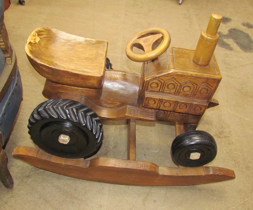 A child's carved wooden rocking tractor