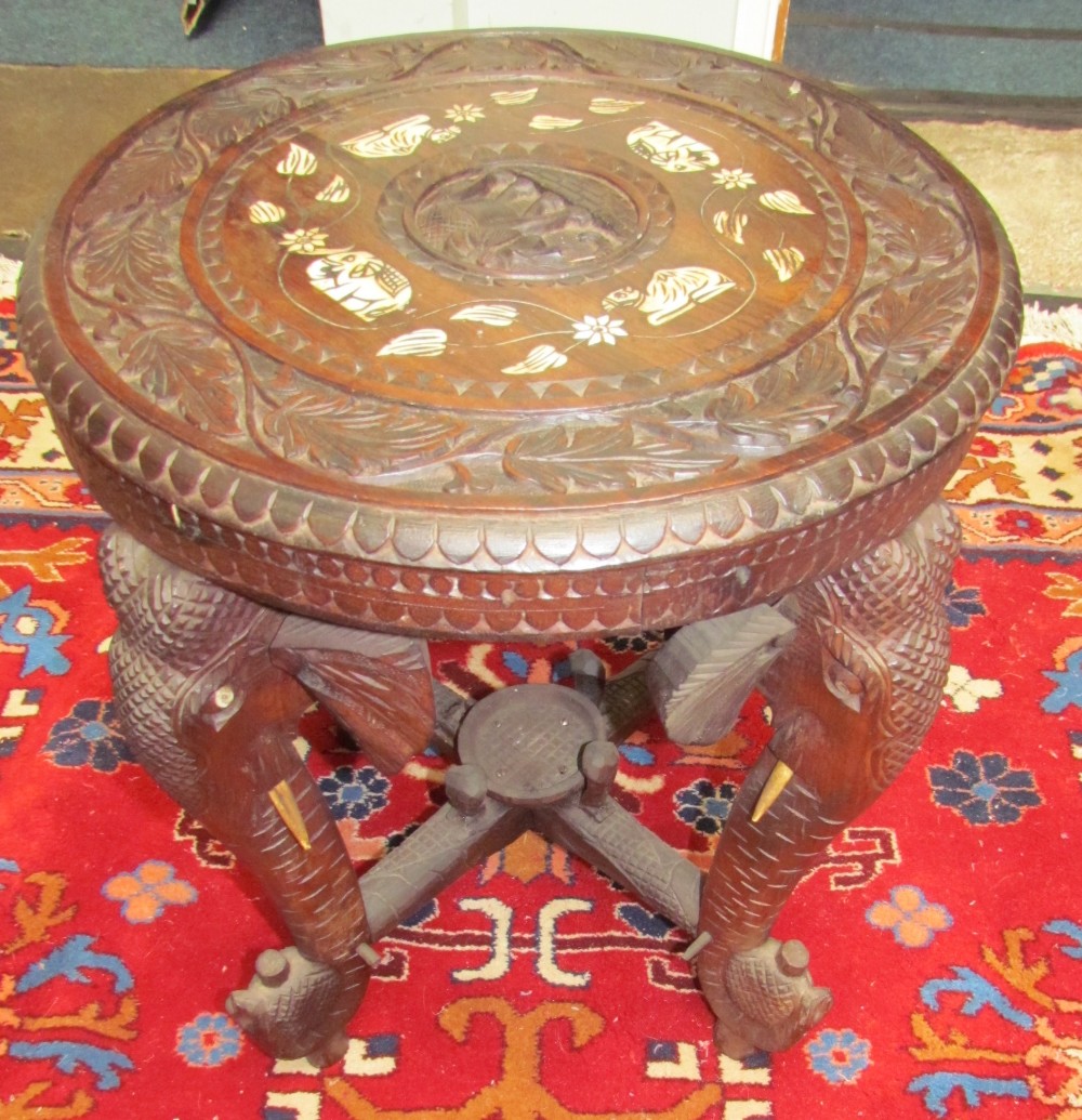 An Indian carved table on elephant head legs,