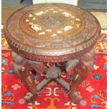 An Indian carved table on elephant head legs,