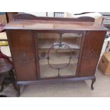 A 20th century mahogany side cabinet with a glazed centre door flanked by two cupboard doors on