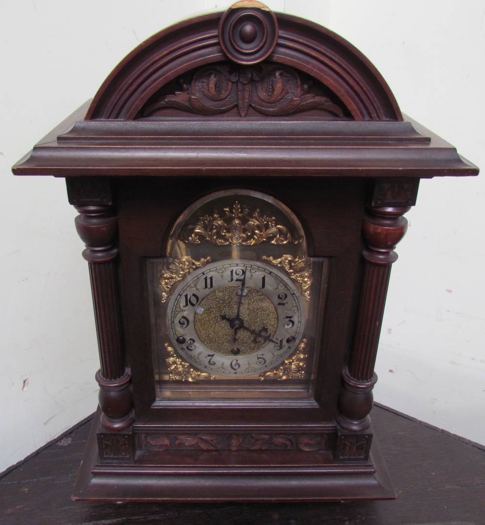 A Kienzle mantle clock, the domed case with a carved cornice and reeded columns,