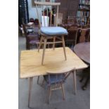 An Ercol style light elm dining table and three chairs