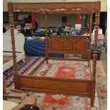 A modern oak four poster king size bed with shaped rails,