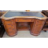 A Victorian mahogany desk with a shaped top inset with leather above a central drawer and two banks