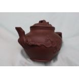 A Yixing pottery teapot, decorated with raised flowers and leaves,