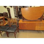 A teak gate leg dining table together with a set of four dining chairs and a sideboard to a design