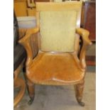 A late 19th century oak office chair with a pad upholstered back,