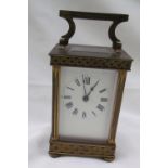 A brass carriage clock with latticework decoration