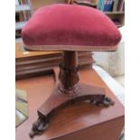 A Victorian rosewood piano stool with a square pad upholstered seat on a leaf carved columns and